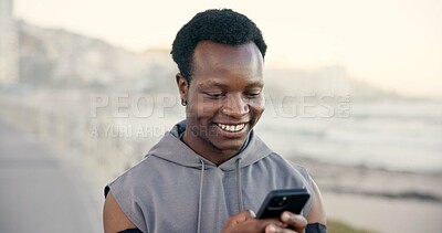 Buy stock photo Black man, phone and smile with fitness app on beach promenade with monitor for training. African person, runner and space with smartphone, notification and happy for exercise on ocean boardwalk