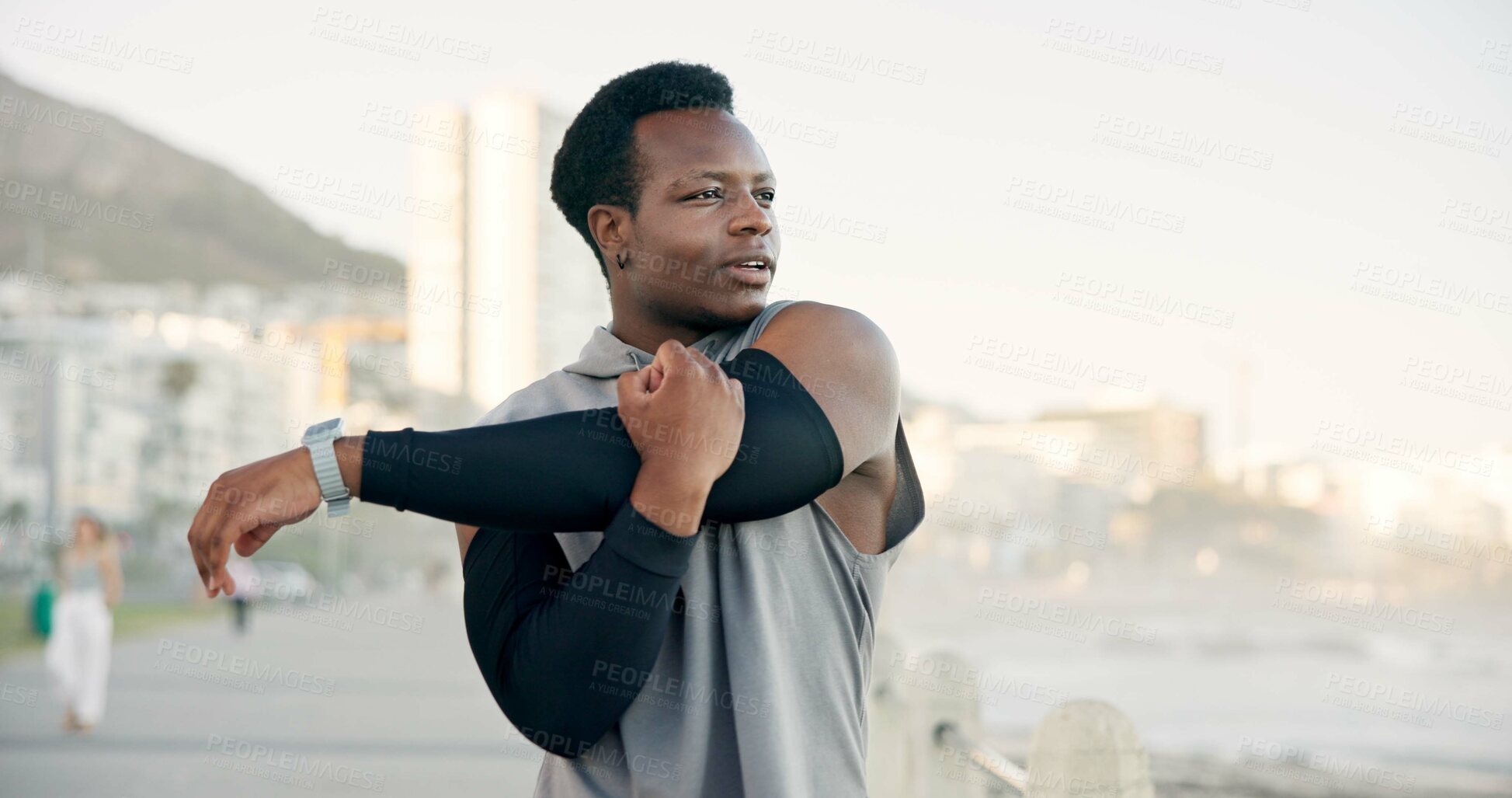 Buy stock photo Man, fitness and stretching with arm on promenade for workout preparation or outdoor training. Active, male person or runner getting ready with warm up for exercise, health or wellness on coast