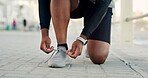 Person, hands and tying with shoes for fitness, workout preparation or outdoor exercise. Active, runner or getting ready with sneakers or laces for physical activity, health and wellness on promenade