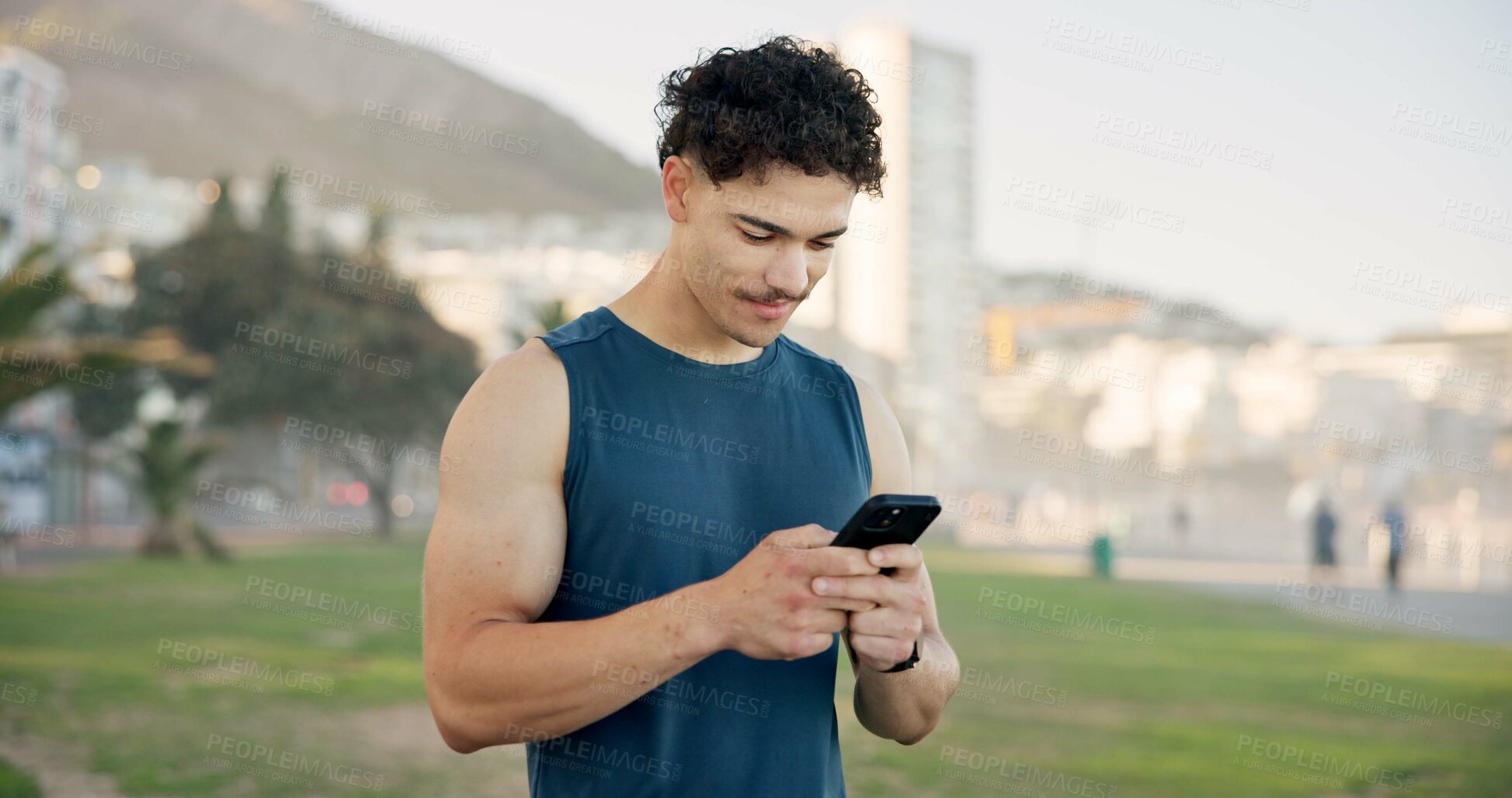 Buy stock photo Man, phone and texting with fitness on beach promenade with smile, break and monitor on application. Person, runner and happy with smartphone, check notification and outdoor for exercise on boardwalk