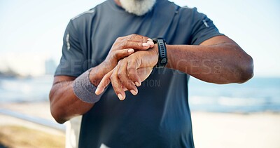 Buy stock photo Old man, hands and smart watch by beach with fitness app, heart rate tracker and monitor performance. Senior person, runner and workout break by ocean with tech, check pace and wellness notification.