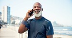 Boardwalk, fitness and mature man with phone call, communication and share location for workout training. Speaking, outdoor space and athlete with mobile for exercise update, break and smile by beach