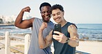 Friends, fitness and selfie with muscle on beach promenade with flexing bicep, excited and post on web. Happy people, photography and strong with social media, space or exercise on seaside boardwalk