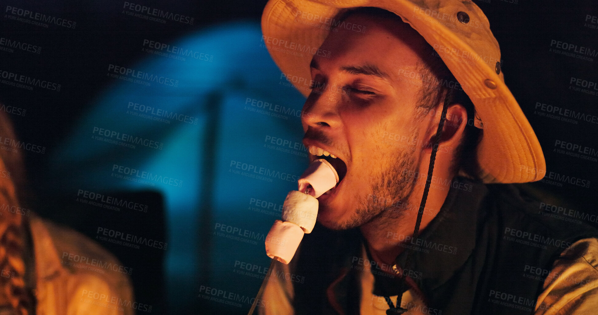 Buy stock photo Happy man, night and eating with marshmallow for camping or sweet outdoor snack in nature. Male person, traveler or dessert with delicious treat in late evening for trip, food or candy in forest