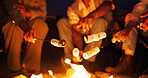 Night, campfire and hands with marshmallow for cooking, holiday travel and outdoor activity for bonding. Candy, friends camping trip and people by flames for weekend break, roasting and late snack