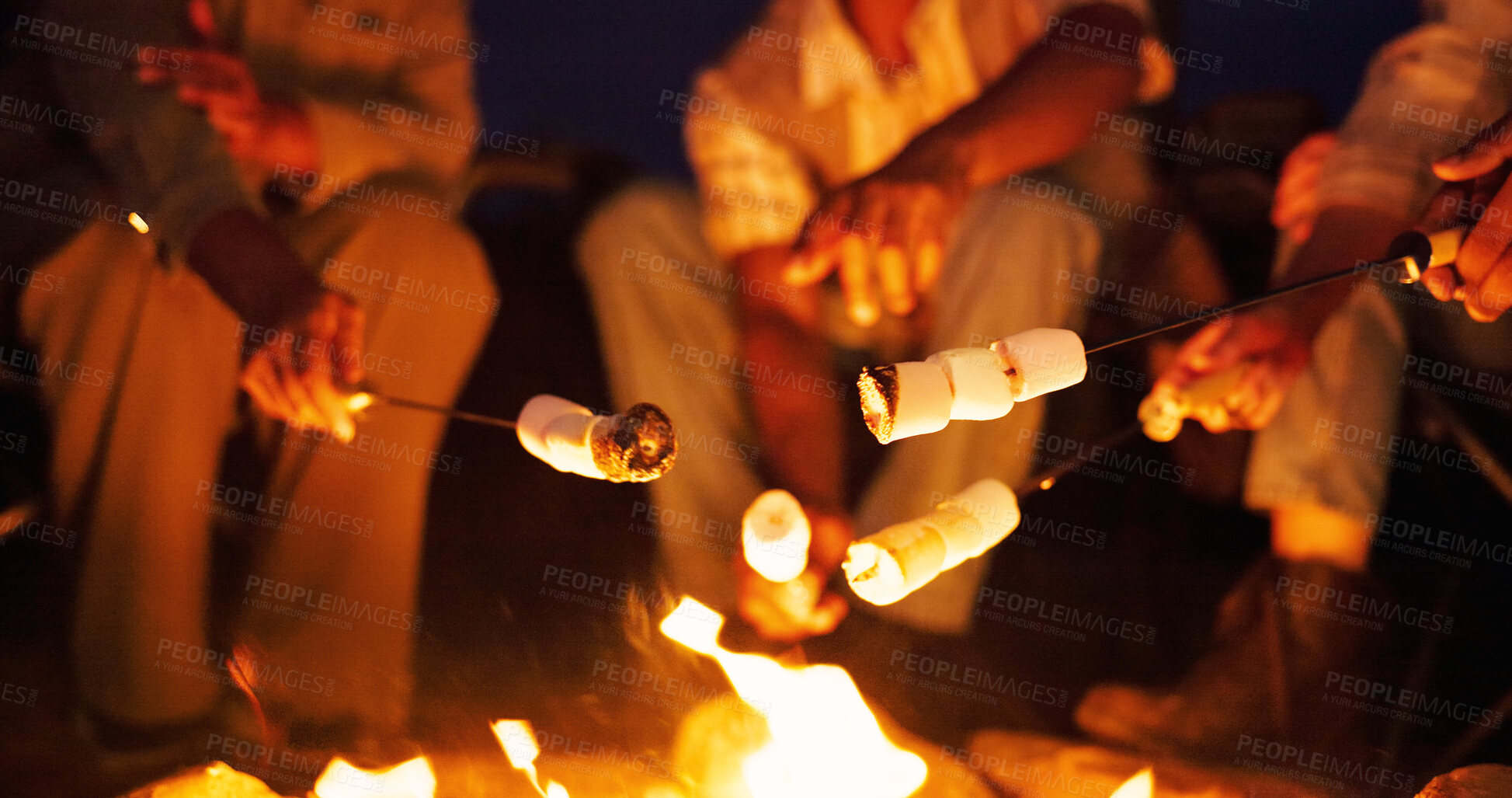 Buy stock photo Night, campfire and hands with marshmallow for cooking, holiday travel and outdoor activity for bonding. Candy, friends camping trip and people by flames for weekend break, roasting and late snack