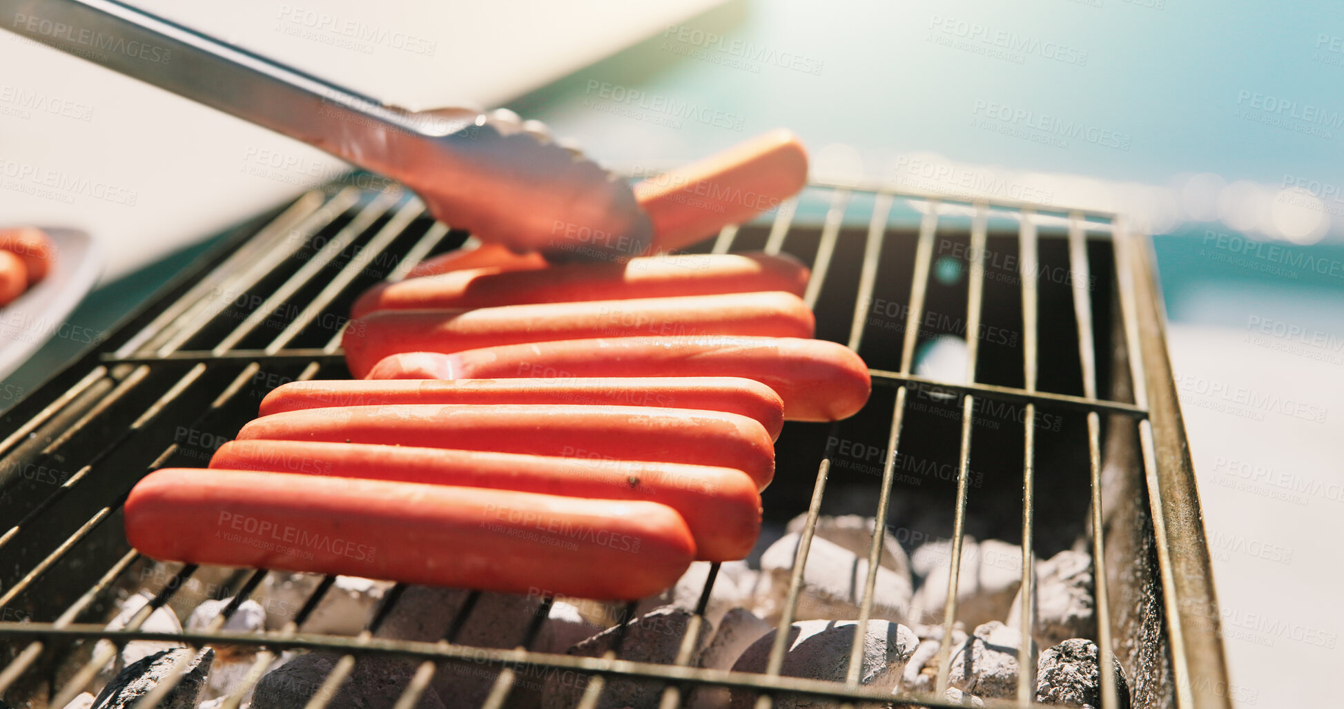 Buy stock photo Bbq, hotdog and tongs with hands of person outdoor for cooking, cookout event and barbecue. Summer vacation, weekend break and grill with cook in backyard of home for meat, lunch and food prep
