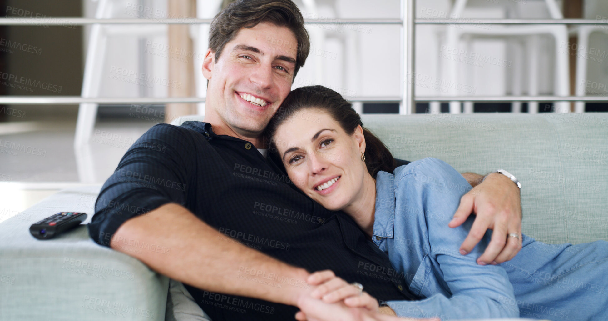 Buy stock photo Watching tv, couple and hug on break, home and bonding with movies, love and affection with partner. People, smile and streaming film on weekend, man and embrace with woman or entertainment in lounge