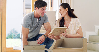 Buy stock photo Couple, photo frame and unpacking for new home, talking and property investment for goals. Rental apartment, man and woman in lounge, cardboard and real estate purchase with mortgage loan and picture