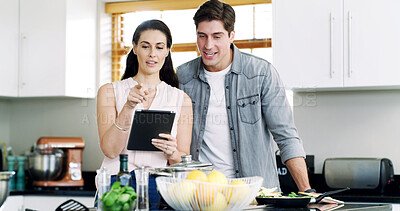 Buy stock photo Talking, cooking and happy couple in kitchen, tablet for online recipe and app for food website. Home, man and tech for nutrition, woman and reading instructions for health meal, help and ingredients