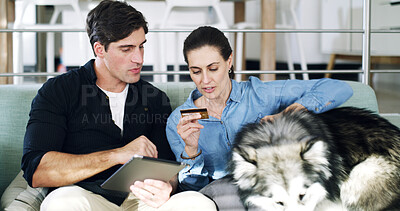 Buy stock photo Dog, credit card and couple on sofa, tablet for animal ecommerce or website info for pet insurance. Conversation, man and woman on couch, home and tech for online shopping and payment for canine care