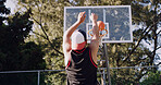 Man, back view and throw with basketball for score, game point or outdoor match on court. Active, male person or aim with shot or technique for playful sport, fitness or physical activity on pitch