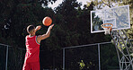 Man, basketball and playing with net on court for score, point or outdoor match in nature. Active, male person or throw with aim, technique or swish shot for fitness, sport or playful game on pitch