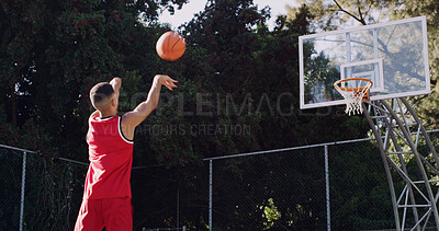 Buy stock photo Man, basketball and playing with ball in net for score, point or outdoor match on court. Active, male person or throw with aim, technique or swish shot for fitness, sport or playful game on pitch