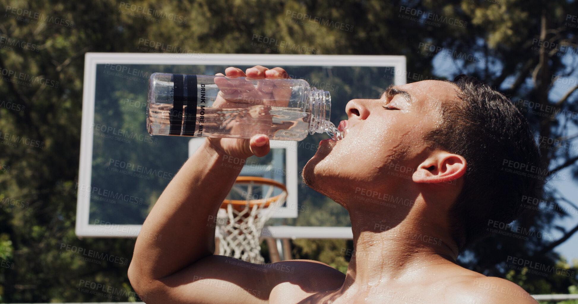 Buy stock photo Man, basketball and drinking with water bottle for hydration, rest or sport break on court. Active, male person or player with mineral liquid for natural sustainability, fitness recovery or health