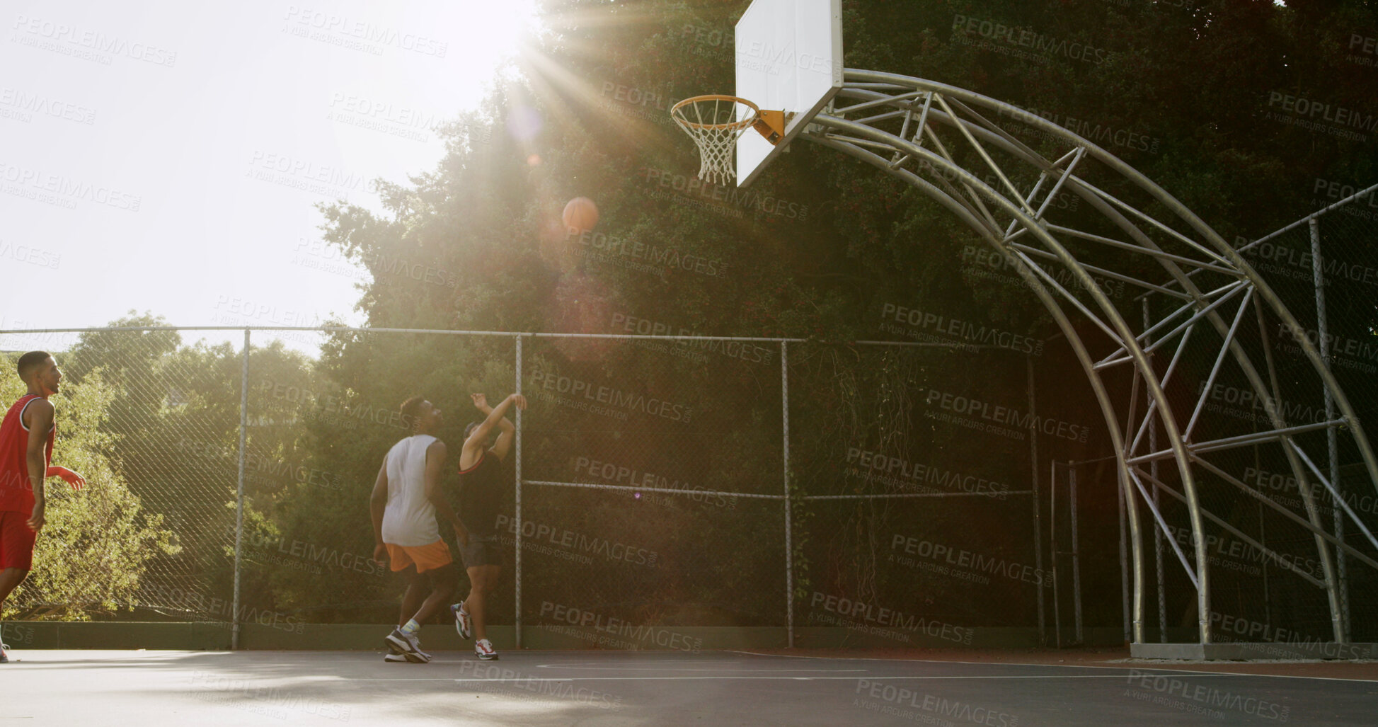 Buy stock photo Basketball, competition and shooting with people outdoor for exercise, fitness or health activity. Flare, game and sports with group of men on court for match practice, tournament or training