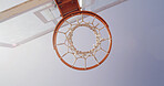 Basketball, net and below for game, court and points for competition, sports and equipment for tournament. Low angle, blue sky and sunshine for match, hoop and target with backboard for summer event