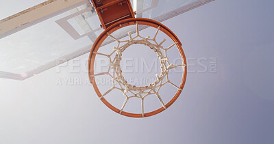 Buy stock photo Basketball, net and below for game, court and points for competition, sports and equipment for tournament. Low angle, blue sky and sunshine for match, hoop and target with backboard for summer event
