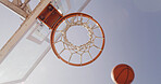 Basketball, net and below for match, court and points for competition, sports and equipment for tournament. Low angle, blue sky and sunshine for game, hoop and target with backboard for summer event