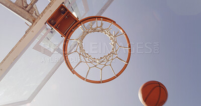 Buy stock photo Basketball, net and below for match, court and points for competition, sports and equipment for tournament. Low angle, blue sky and sunshine for game, hoop and target with backboard for summer event