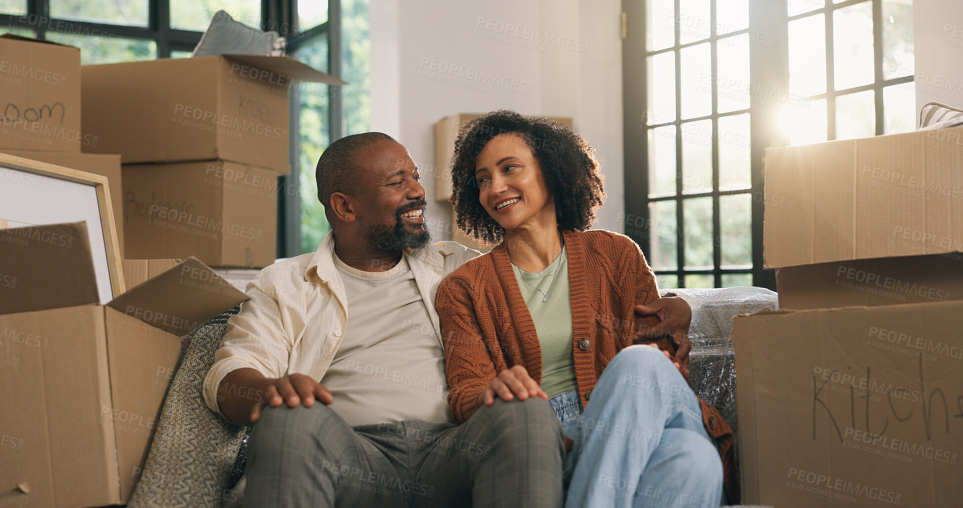 Buy stock photo Moving, couple and relax in new home, hug and relocation for property investment with partner. African man, woman and embrace in dream house with mature people, real estate and happiness with boxes