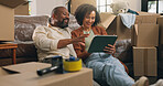 Boxes, relax and tablet with African couple in new home together for planning or property investment. App, conversation and real estate with people on apartment floor for moving house or relocation