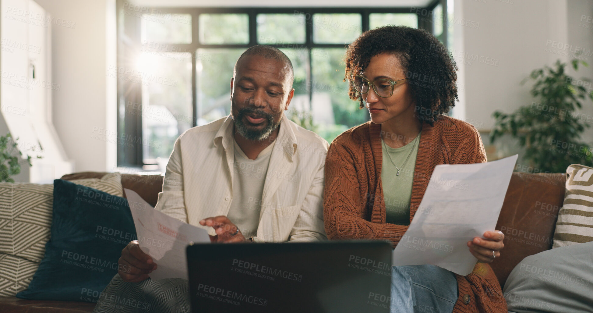 Buy stock photo Discussion, document or couple with laptop on sofa, budget planning or track expenses for savings. Talking, income statement or mature African people with mortgage invoice, review bills or pc in home