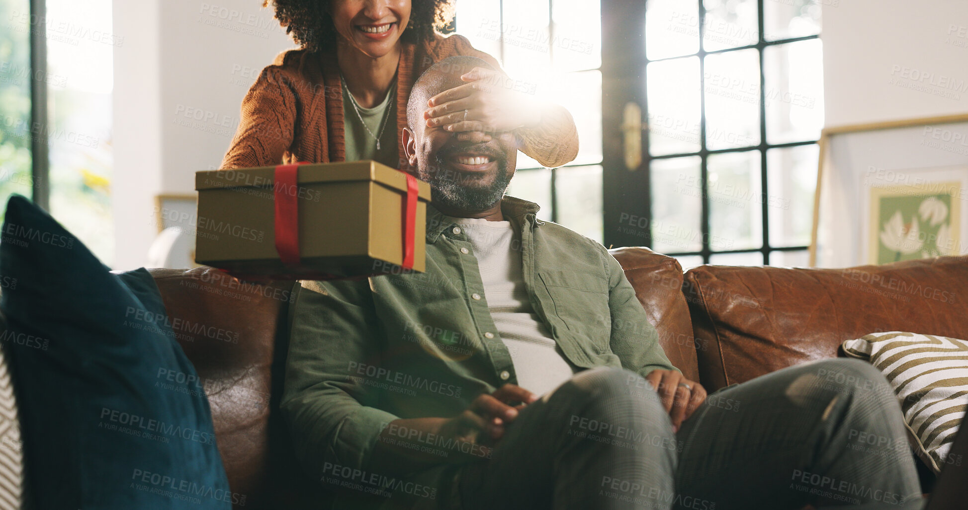 Buy stock photo Gift, surprise and couple in lounge, cover eyes and celebration for anniversary. House, woman and man on sofa, present and wow with gratitude, birthday and mature people with happiness and romance
