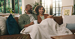 Happy couple, relax and watching tv with blanket on sofa for subscription or entertainment in home. Man, woman or bonding with smile or comfort on couch for movie, online streaming or series in house