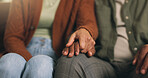 Couple, holding hands and support with comfort on sofa for understanding or bonding in home. Closeup, man and woman with love, care or commitment for relationship, sympathy or trust together in house