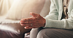 Hands, holy and prayer with senior person on sofa in living room of home for belief in God. Faith, praying and religion with elderly Christian in apartment for healing, spirituality or trust in Jesus