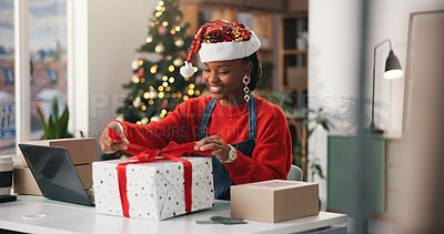 Buy stock photo Christmas, gift and wrapping with black woman in office for holiday celebration, startup or laptop. Festive season, present and dropshipping with employee and box for secret Santa and small business
