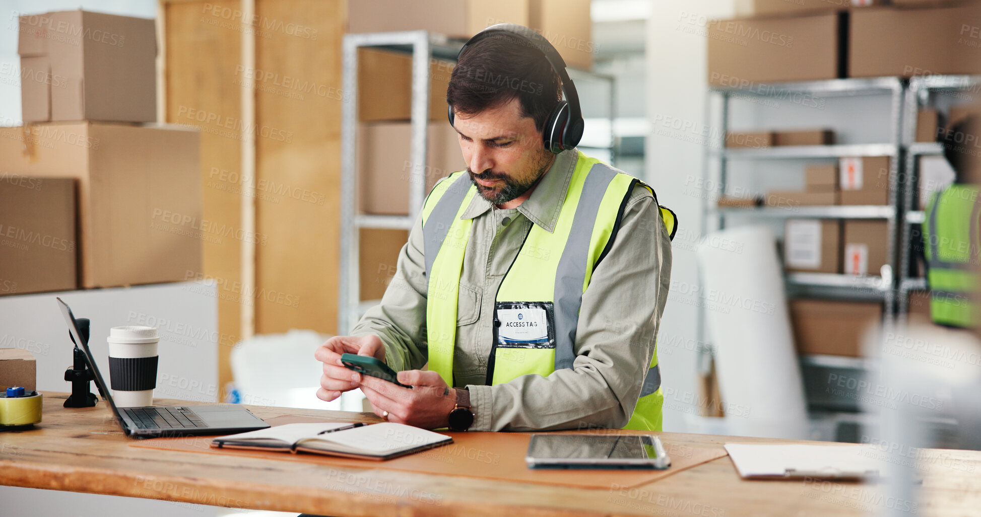 Buy stock photo Logistics, smartphone and man with headphones, texting and communication with supplier for delivery. Entrepreneur, online and person with mobile for message, dropshipping or streaming music with tech