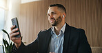 Business, man and phone with earphones in office for social media, streaming podcast and chat. Male person, reading and mobile to download playlist, listening to music and subscription for work break