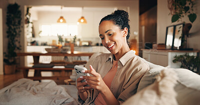 Buy stock photo Woman, smile and reading in home with phone, text message notification and website for digital news. Female person, typing and browsing on sofa with tech, social media or mobile app for blog article.