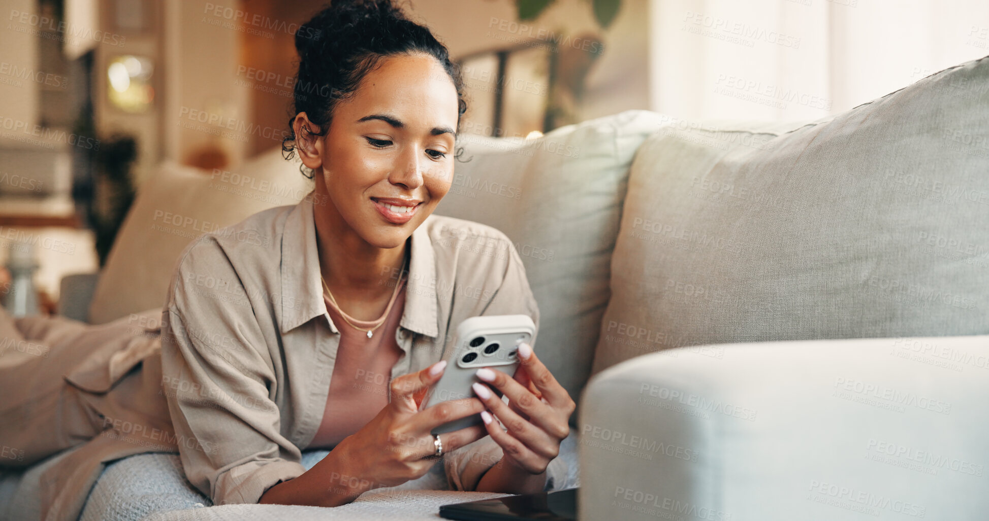 Buy stock photo Woman, smile and browsing in home with phone, text message notification or website for digital news. Female person, typing and reading on sofa with tech, social media and mobile app for blog article.