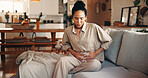Woman, stomach ache or period with pain on sofa for indigestion or menstruation cycle in home. Female person, discomfort or sore tummy bug with cramps or gastrointestinal reflux for virus or diarrhea