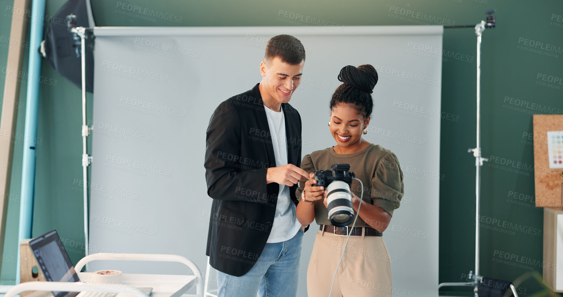 Buy stock photo Speaking, photographer and model with camera in studio, review image or tips for expression check. Photography, creative or happy people with chat for picture selection, production or photoshoot idea