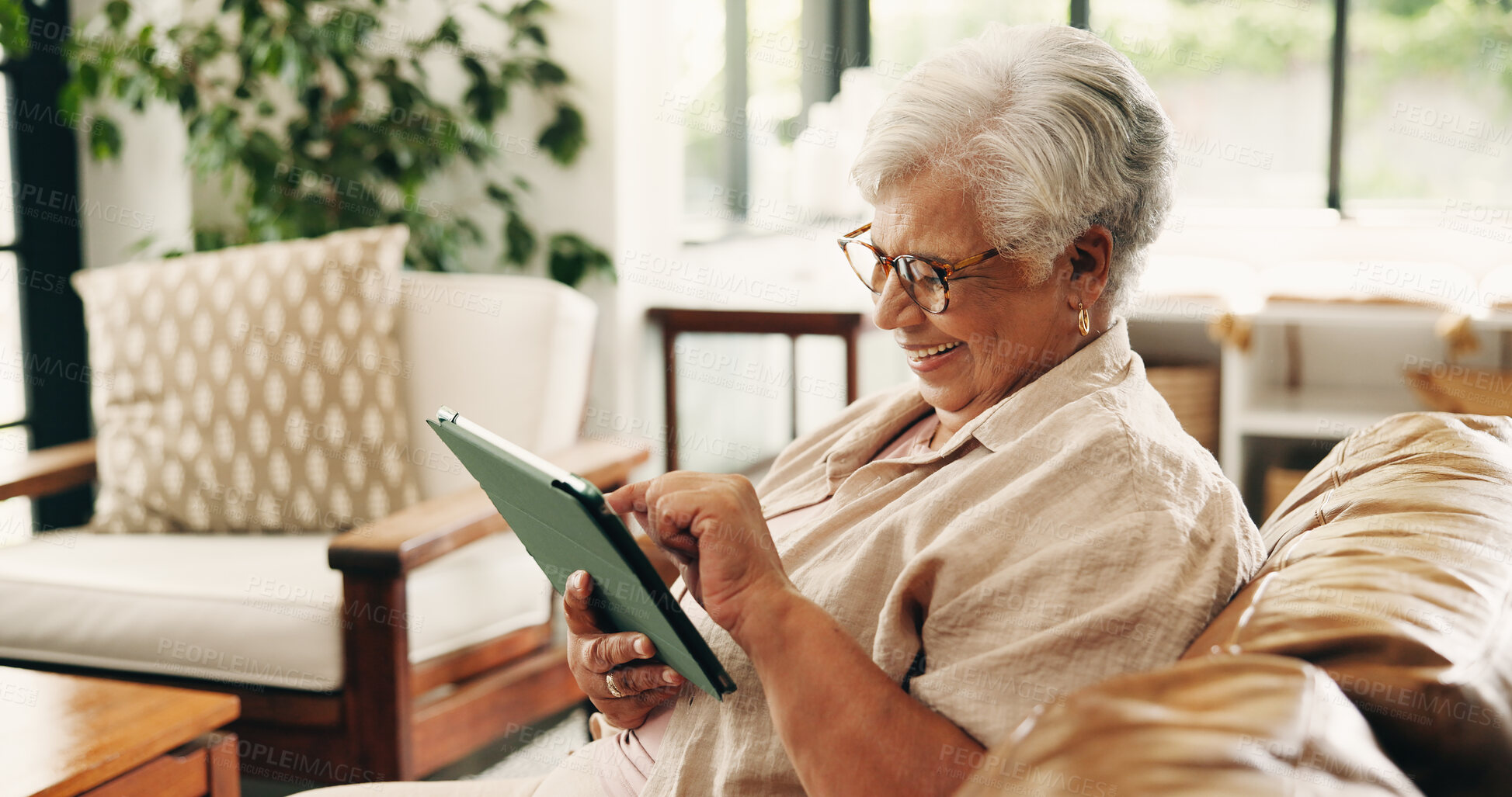 Buy stock photo Reading, tablet or senior woman on couch, word game app or online brain teaser for retirement wellness. Smile, crossword puzzle or old person with tech in home, play memory activity or entertainment