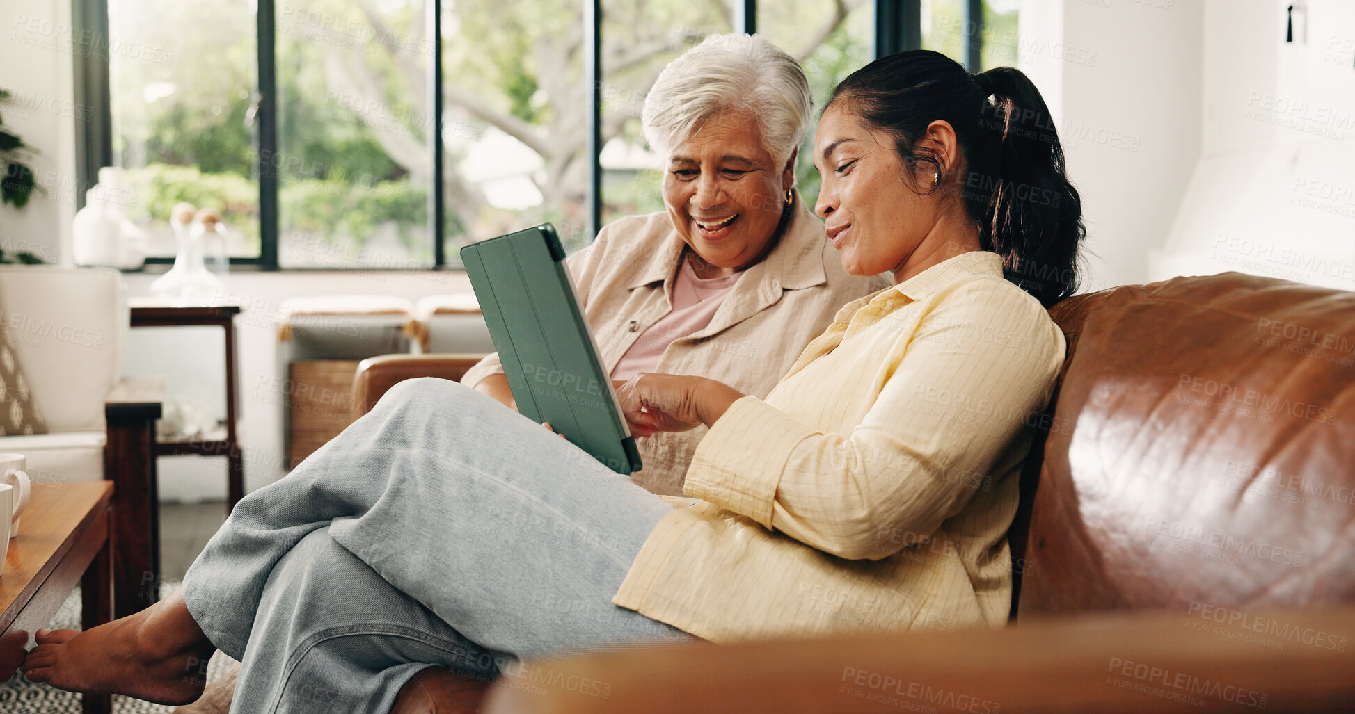 Buy stock photo Tablet, senior mother and daughter on couch, digital photo album and view nostalgic image for bonding. Smile, check social media and women with tech to watch family movie, browsing together and home