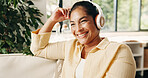 Happy, woman and thinking in home with headphones, podcast and listening to music on weekend break. Mature person, smile and relax in living room with audio tech, online playlist and streaming radio.