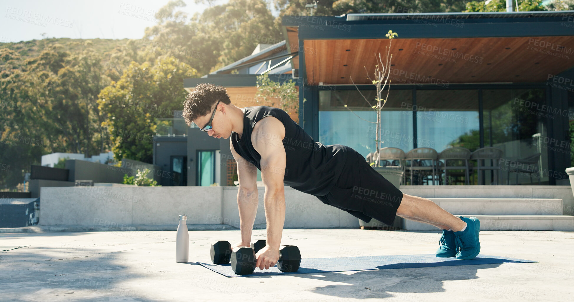 Buy stock photo Athlete, man and outdoor with dumbbells for workout, muscle development and health. Sunglasses, fitness and bodybuilder person with weights for exercise by home for push up, challenge and training