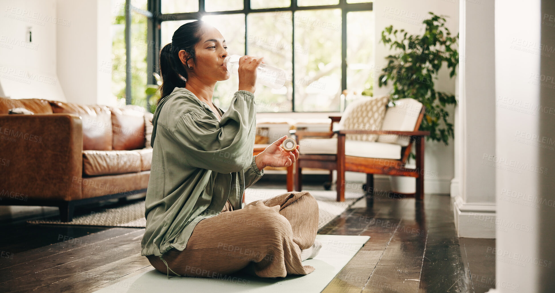 Buy stock photo Yoga, woman and drinking water in living room with bottle, fitness and hydration break for wellness. Flare, mature person and liquid beverage in home lounge with exercise rest, thirst and self care.