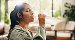 Thirsty, woman and drinking water in lounge with bottle, wellness and natural detox for gut health. Flare, mature person and liquid beverage in house with hydration, nutrients and digestion benefits.