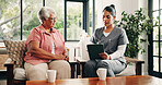 Healthcare, tablet or review with nurse and old woman talking in home living room for feedback. App, discussion or medical checkup with caregiver and senior patient in apartment for diagnosis