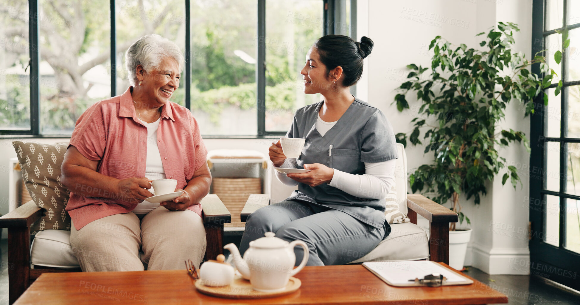 Buy stock photo Happy, caregiver and drinking tea in nursing home with old woman, visit and support for bonding together. People smile, senior person and nurse in retirement center with beverage, trust and kindness.
