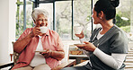 Caregiver, talk and drinking tea in nursing home with old woman, visit and support for bonding together. Happy, senior person and nurse in retirement center with warm beverage, trust or conversation.