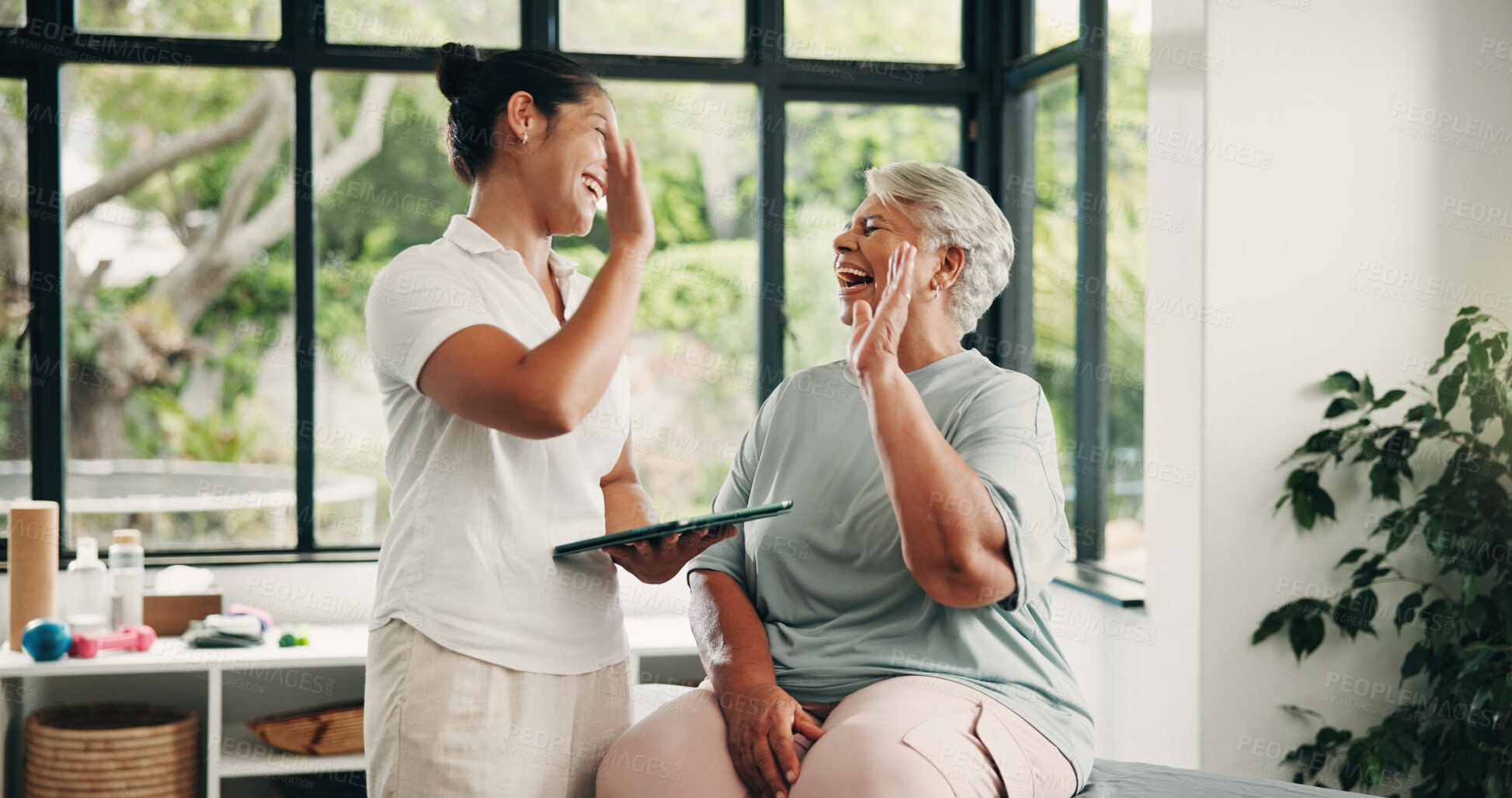 Buy stock photo Physiotherapy, tablet or old woman with high five in clinic, checkup or healing progress celebration. Laughing, tech or senior person with specialist for mobility recovery, rehab success or smile