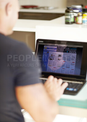 Buy stock photo Man, laptop screen and research on website product or supplements on kitchen table at home. Rear view of male person searching on computer for online information, browsing or pharmaceutical knowledge