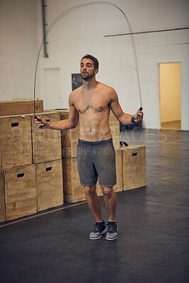 Buy stock photo Exercise, fitness and jump rope with man in gym for training, muscle connection and workout. Health, agility and sports athlete with male person and skipping for energy, cardio and strength movement